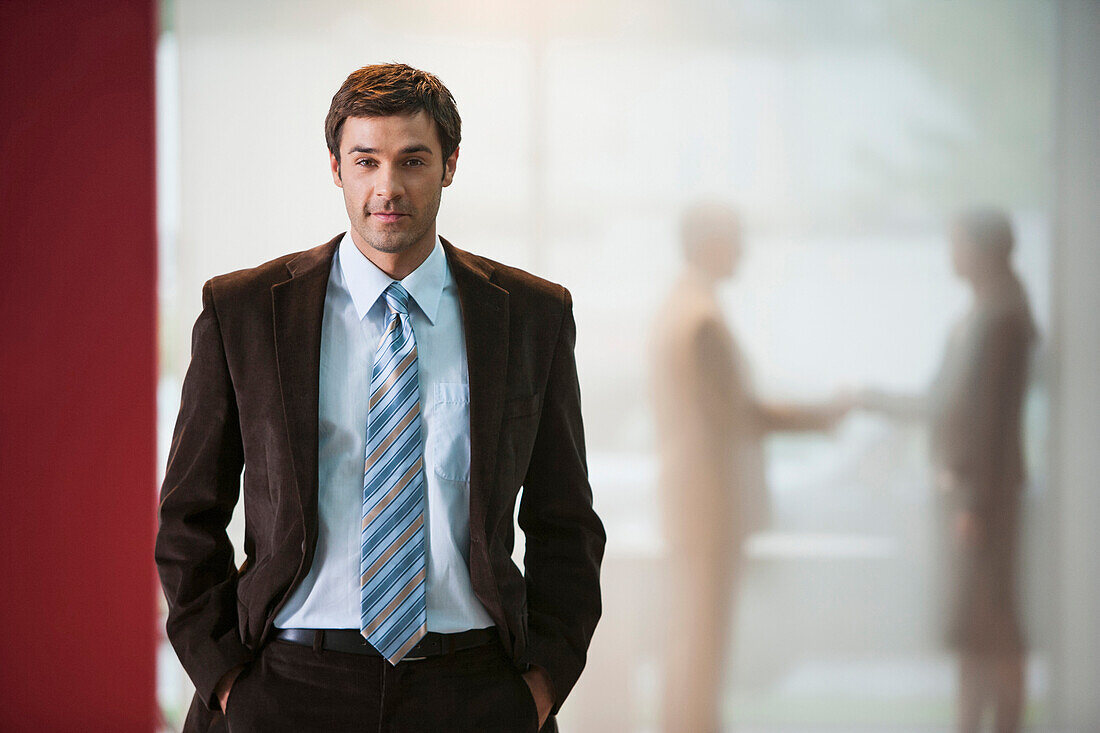 Businessman with hands in pockets in office, Cape Town, Western Cape, South Africa