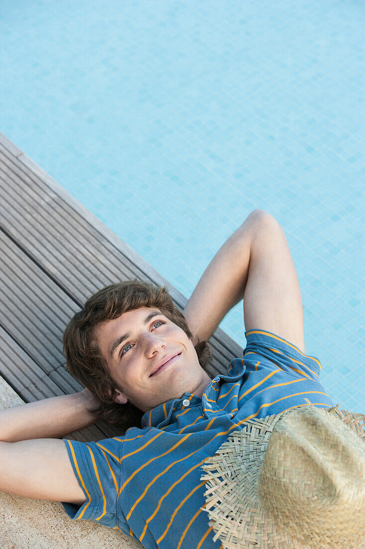 Man relaxing by swimming pool, Palma de Mallorca, Balearic Islands, Spain