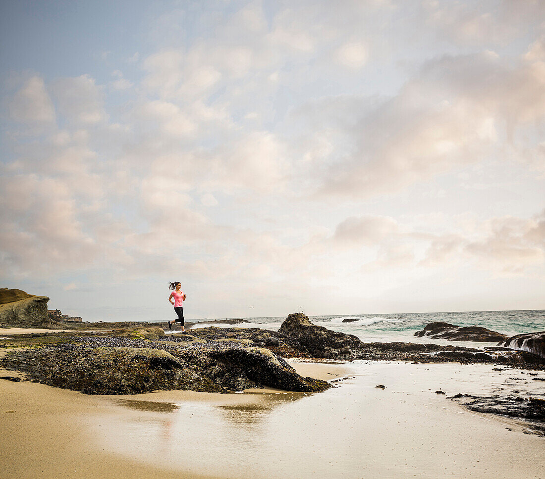 Caucasian woman running on beach, Los Angeles, California, USA