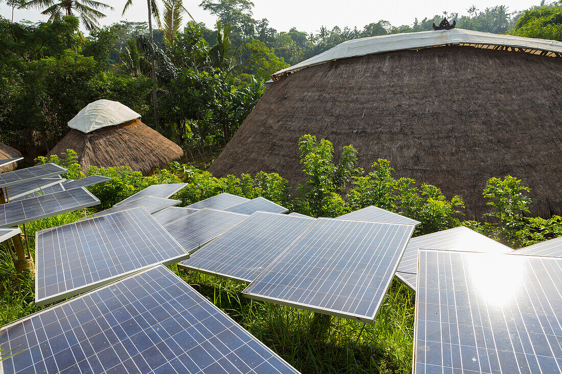 Solar panels among thatched roof buildings, Ubud, Bali, Indonesia