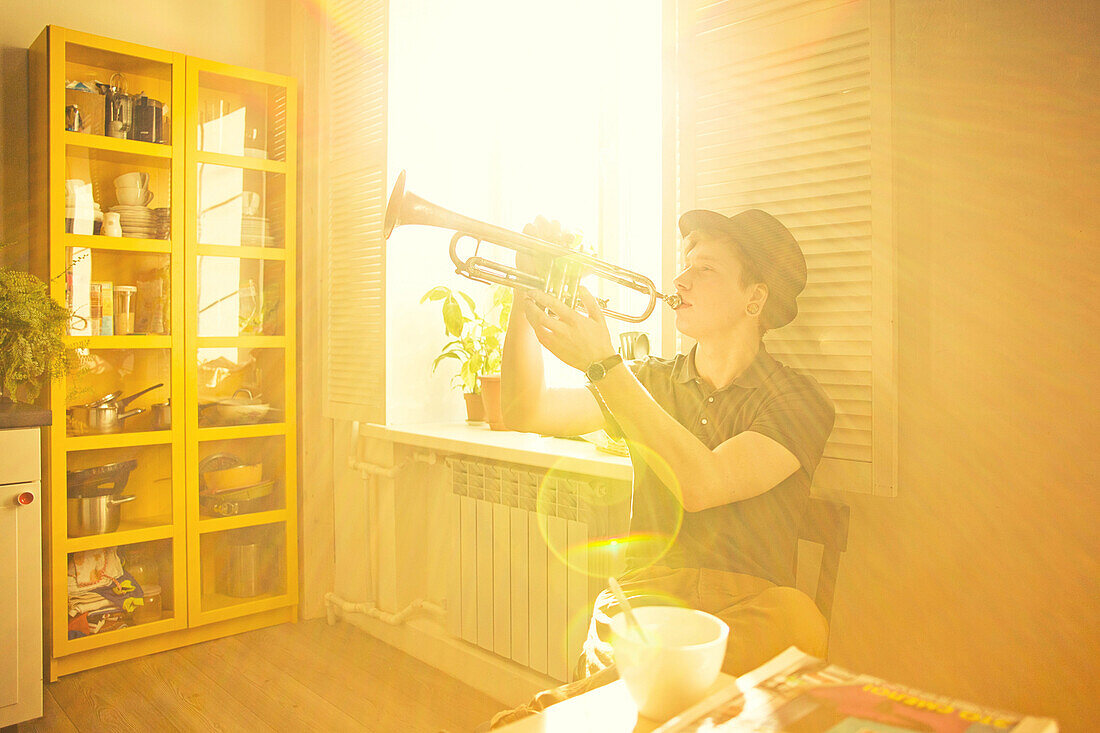 Caucasian man playing trumpet in kitchen, Nizhniy Tagil, Sverdlovsk region, Russia