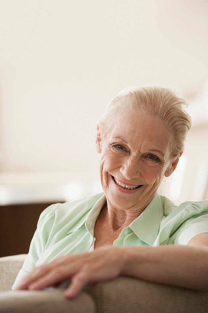 Senior Caucasian woman smiling on sofa, Cape Town, Western Cape, South Africa