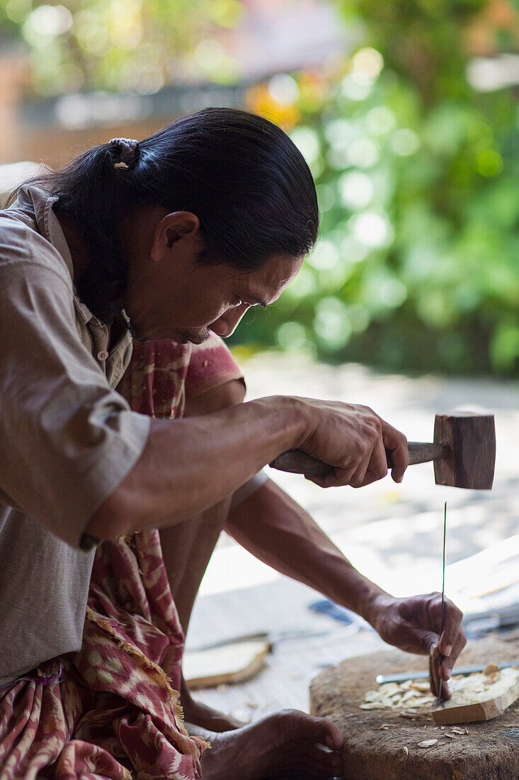 Wood worker chiseling piece in studio, Mas, Bali, Indonesia