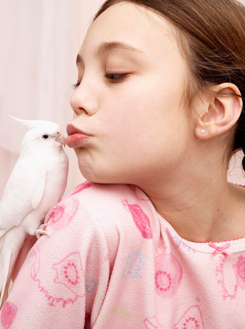 Mixed race girl kissing bird, San Rafael, California, USA