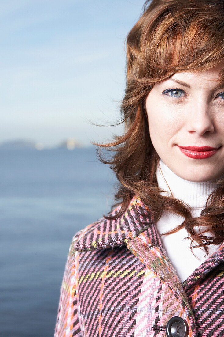 Mixed race woman smiling by waterfront, Sausalito, California, USA