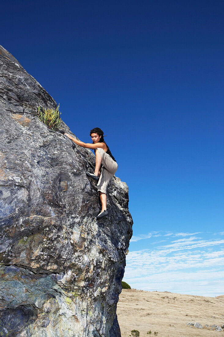 Hispanic climber scaling steep rock face, Tiburon, California, USA