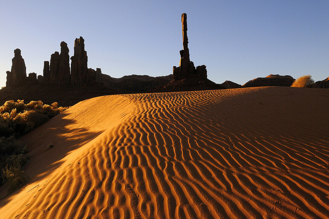 TOTEM POLE AND YEI BI CHEI ON SAND DUNE, MONUMENT VALLEY NAVAJO TRIBAL PARK, ARIZONA, USA