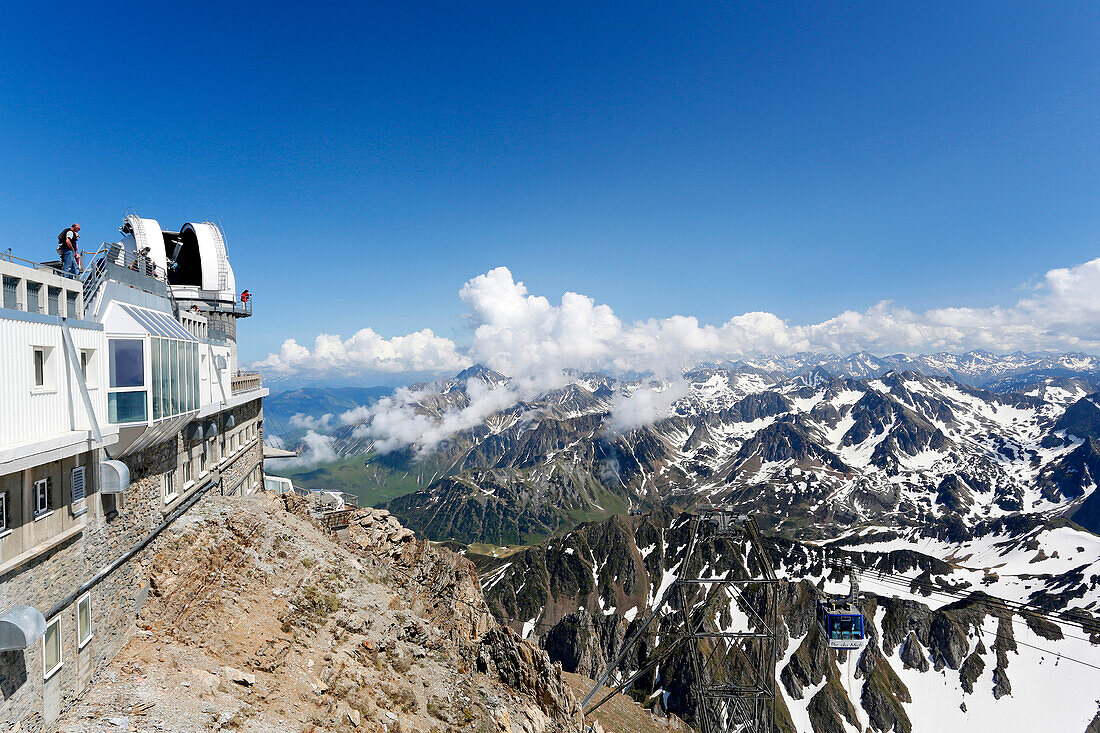 France, Hautes Pyrenees. Pic du Midi Observatory. Tourists trying to observe the panorama and the cable.