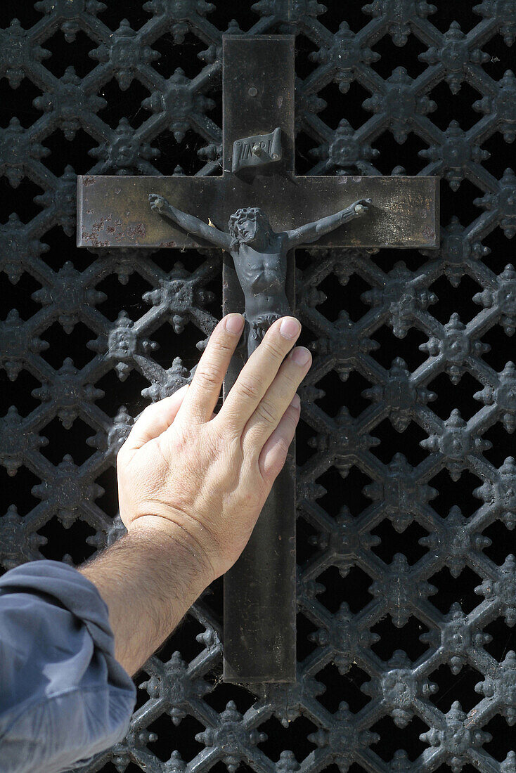 Hand on a crucifix. Paris. France.