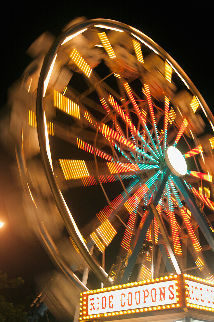 'Ferris wheel illuminated in colourful lights at night; Honolulu, Oahu, Hawaii, United States of America'