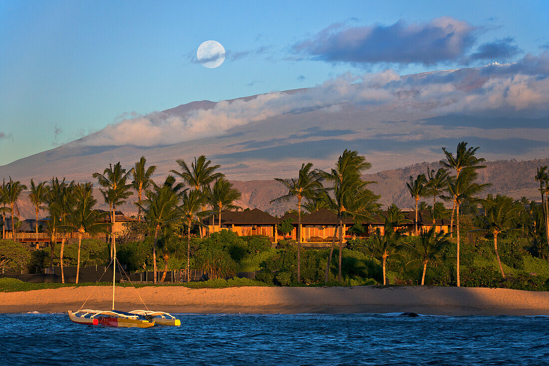 'An outrigger canoe in Kukio Bay with a view of Mauna Kea in the distance; Big Island, Hawaii, United States of America'