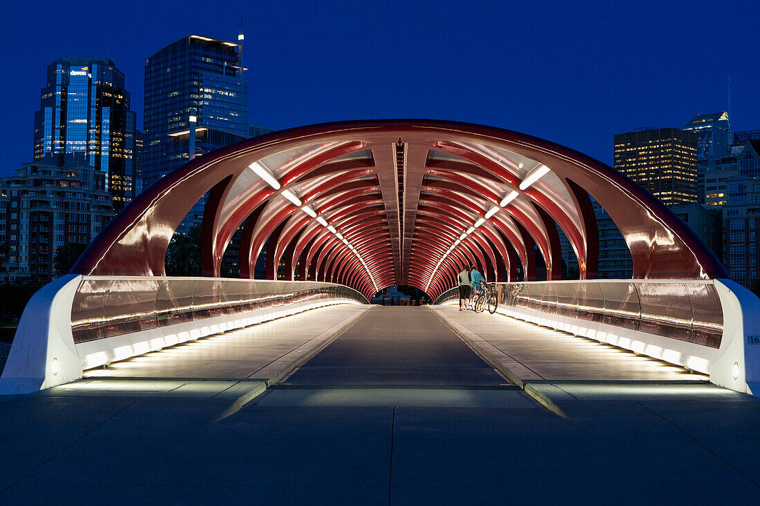 'Red Bridge At Night With Lights And City Buildings In The Background; Calgary, Alberta, Canada'