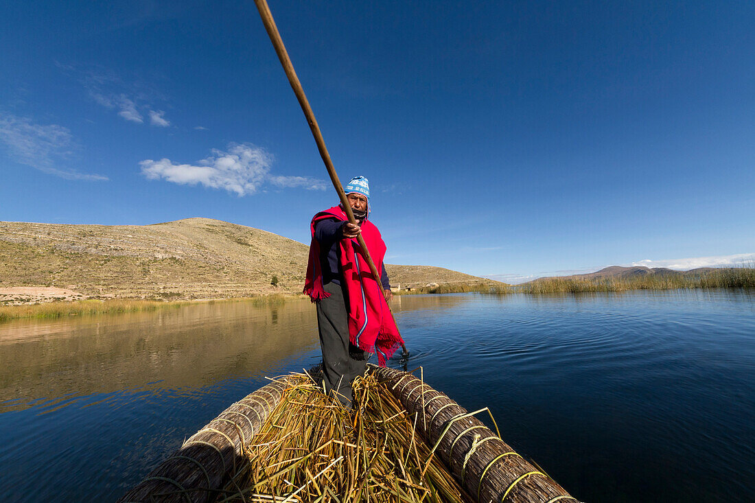 Aymara man rowing a totora reed boat on Lake Titicaca, La Paz Department, Bolivia