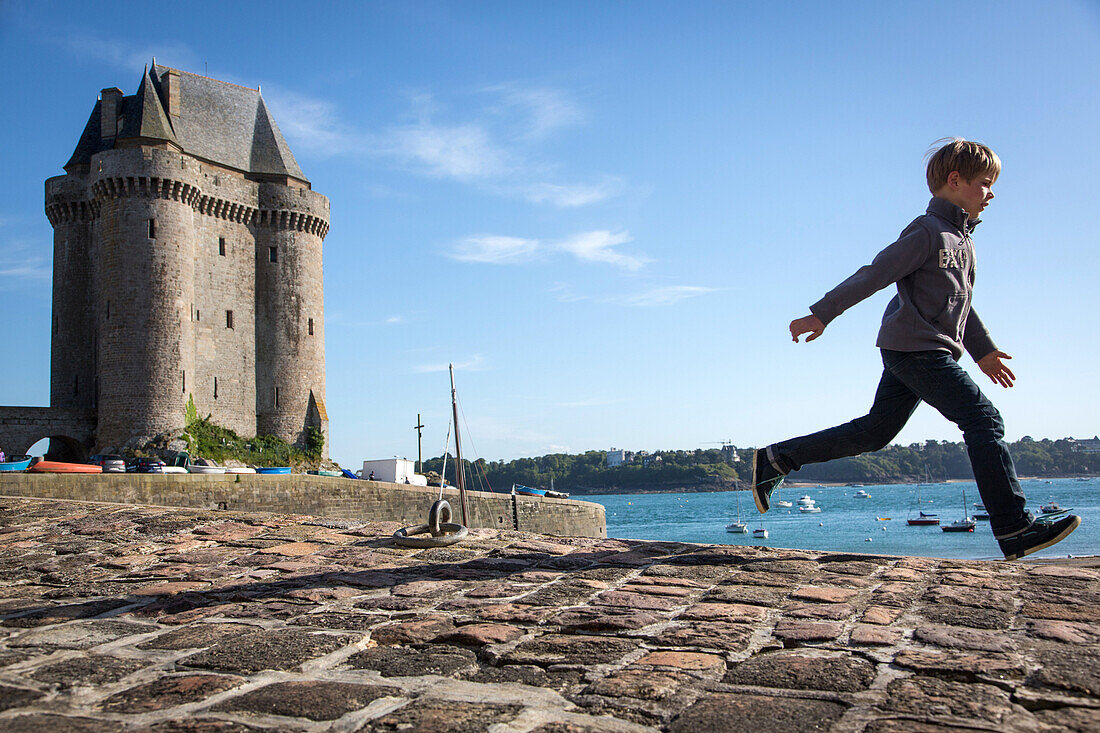 Child on the port of the bas-sablons and the solidor tower, city of alet, saint-servan quarter, saint malo, ille-et-vilaine (35), france