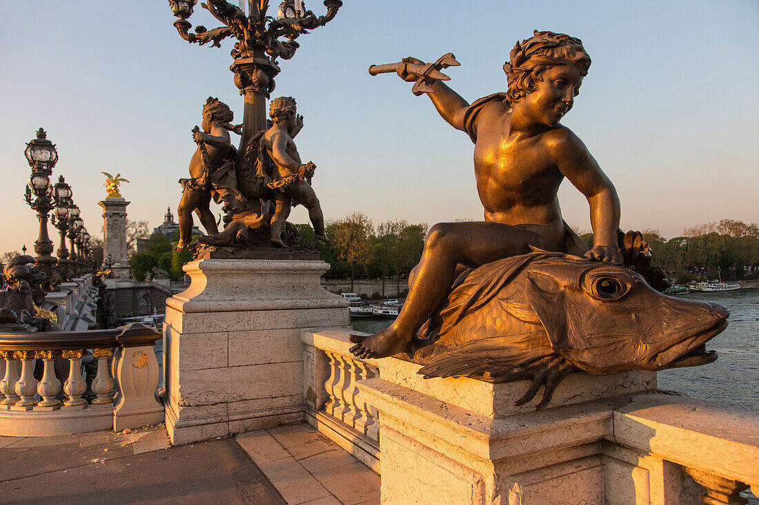 Statue of the child with fish or the genie with a trident by andre massoule, detail of the pont alexandre iii bridge over the seine, paris, france