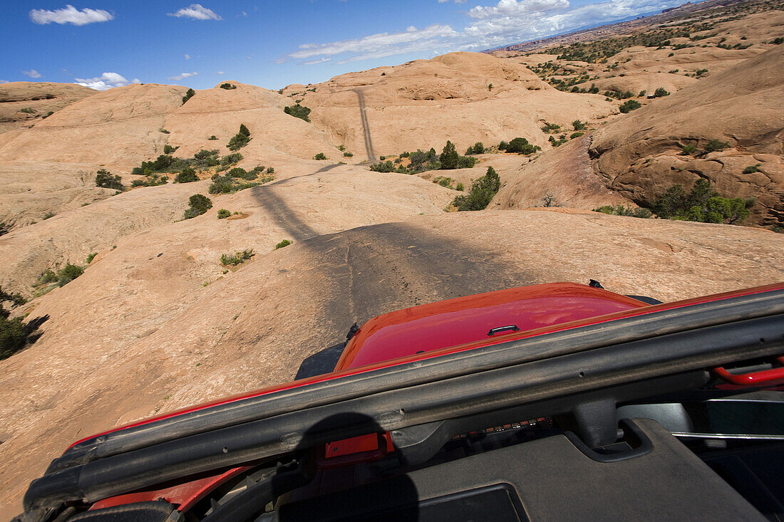 View of Remote Road Across Red Rocks Through Jeep Sunroof, Moab, Utah, USA
