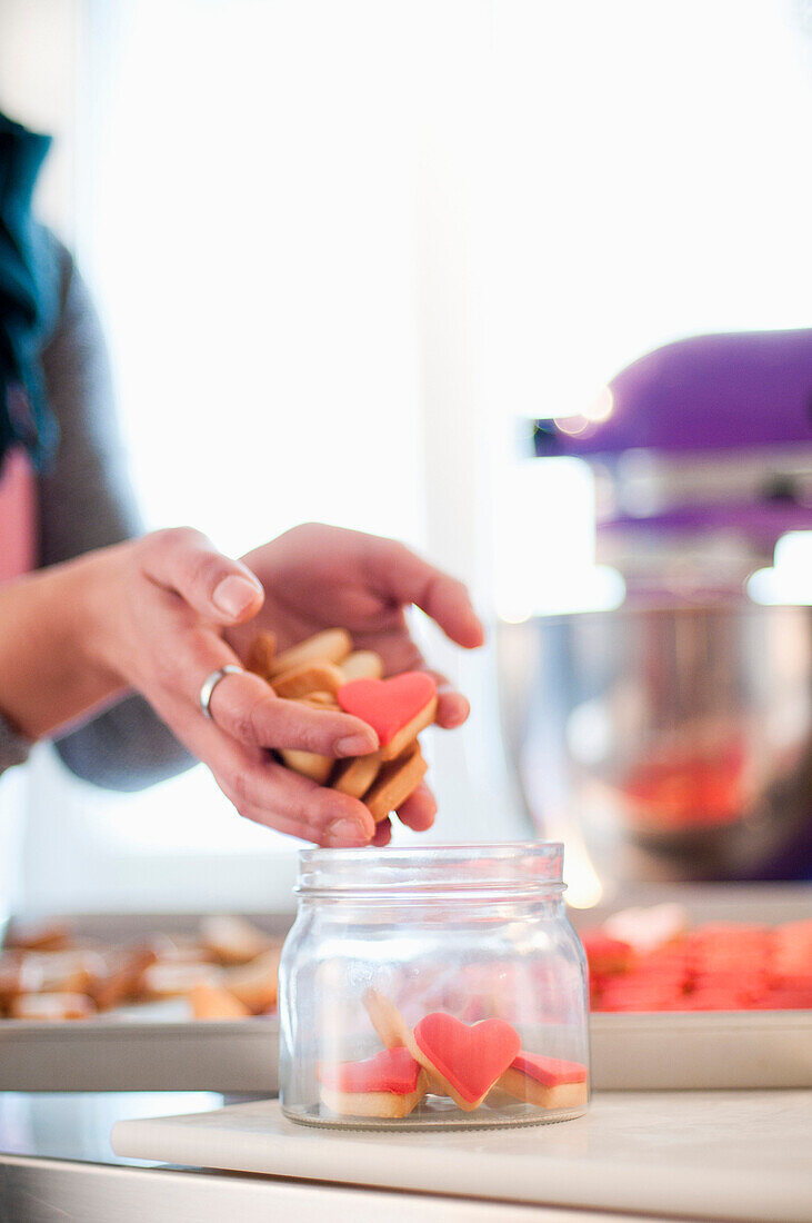 Woman Putting Cookies in Jar