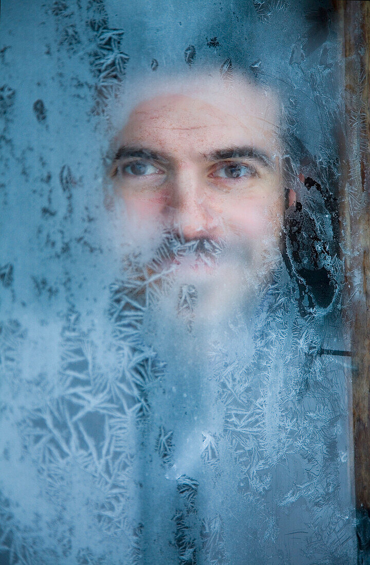 Man Peeking Through Frosted Window