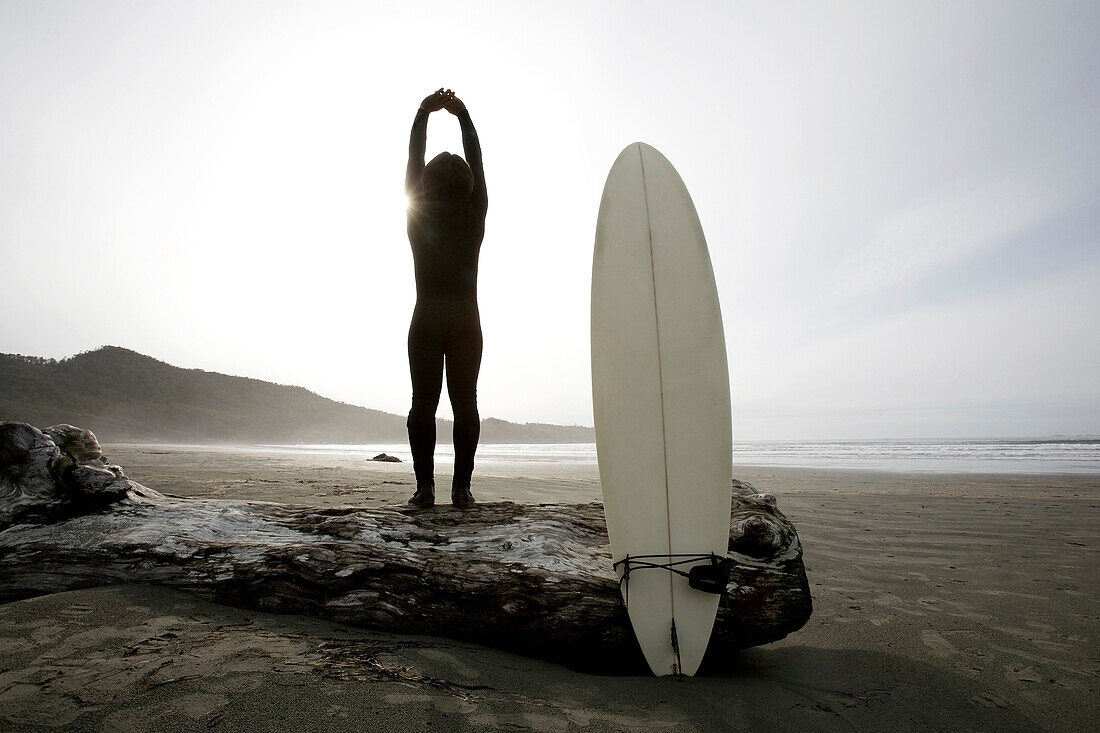 Surfer Stretching On Beach