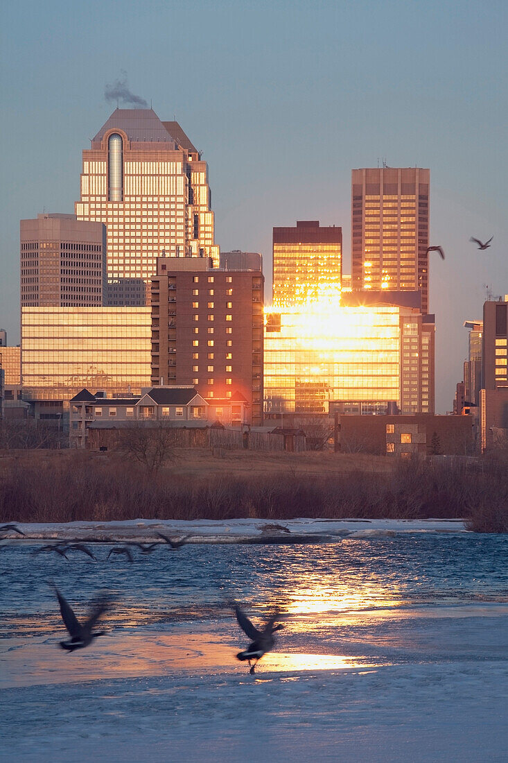 'Calgary, Alberta, Canada; Bow River And Buildings Reflecting The Sun In Winter'