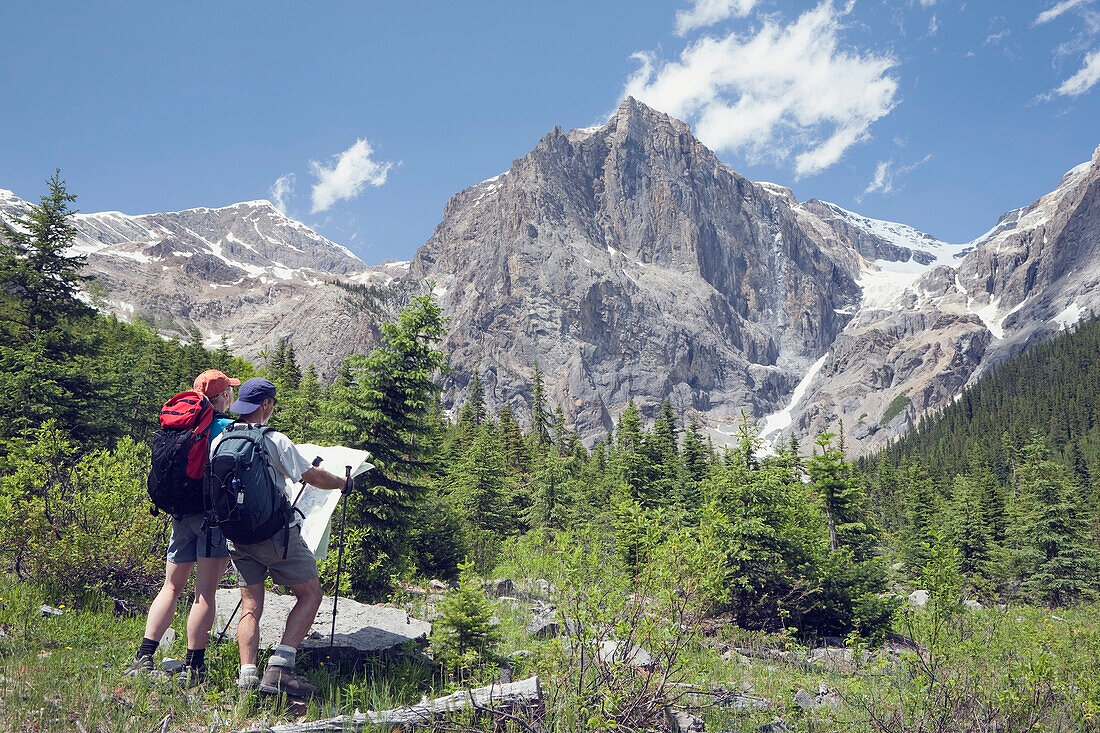 'Yoho National Park, British Columbia, Canada; A Couple Hiking Through The Mountains And Looking At A Map'