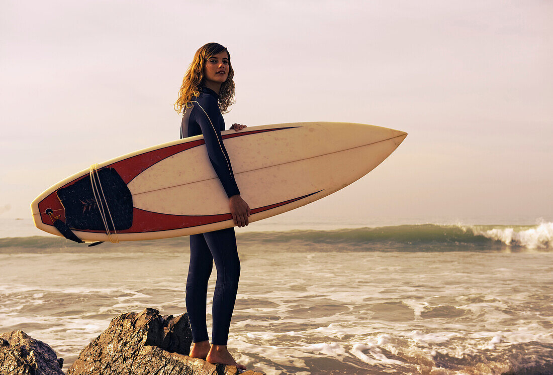 'Young Woman With Her Surfboard At The Beach; Tarifa, Cadiz, Andalusia, Spain'