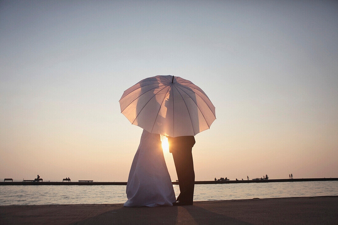 Silhouette Of A Bride And Groom Behind An Umbrella