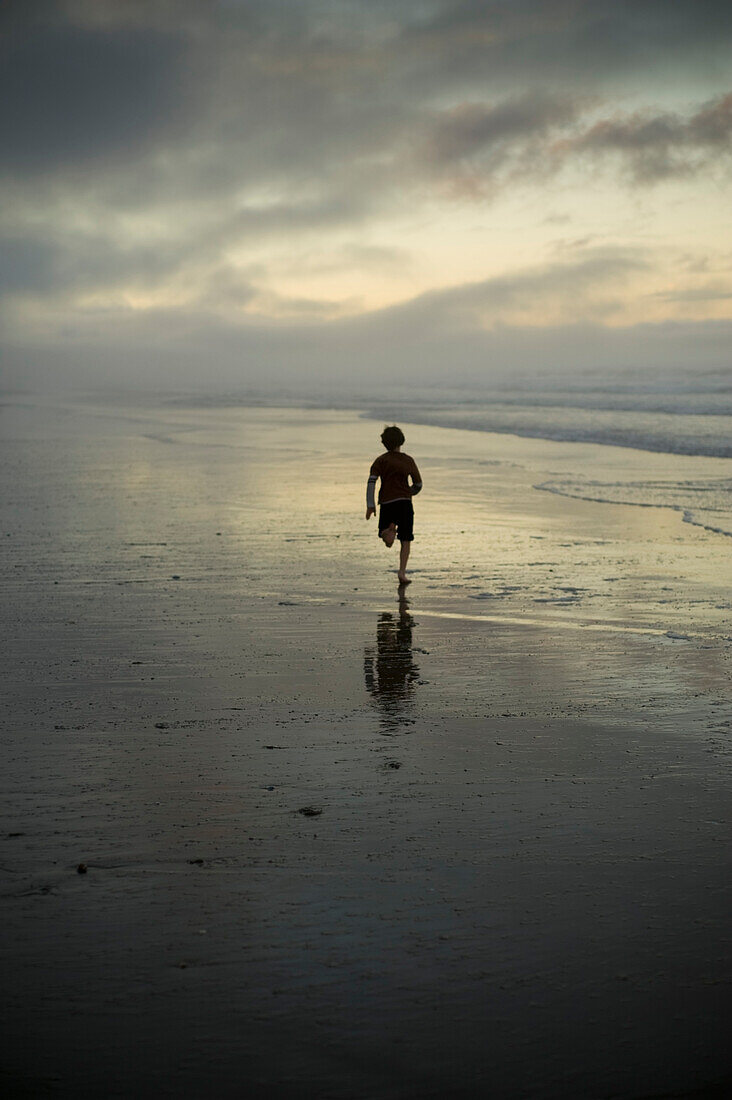 A Person Running On The Beach At Sunset