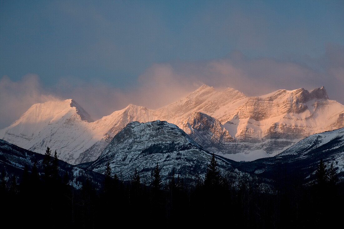 'Alberta, Canada; Fog Around The Snow Covered Mountain Range At Sunrise In Kananaskis Country'