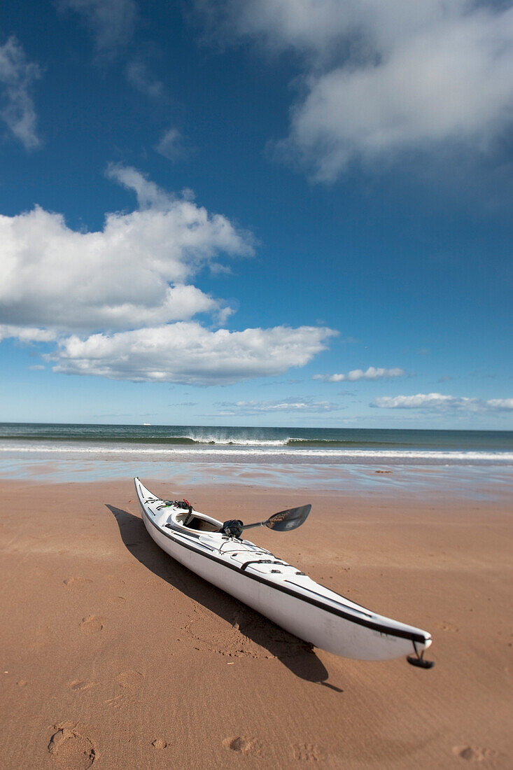 'Northumberland, England; A Kayak Sitting On The Sand On Low Newton Beach'