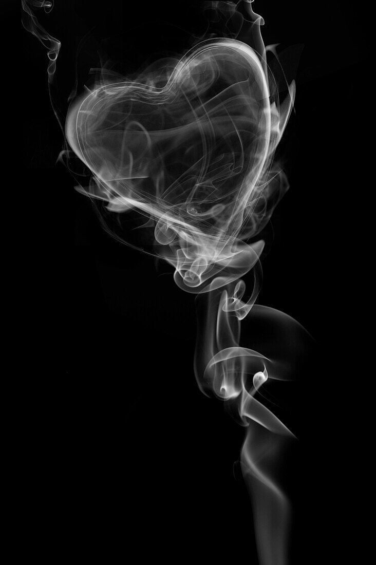 Wisps Of White Smoke In The Shape Of A Heart Against A Black Background