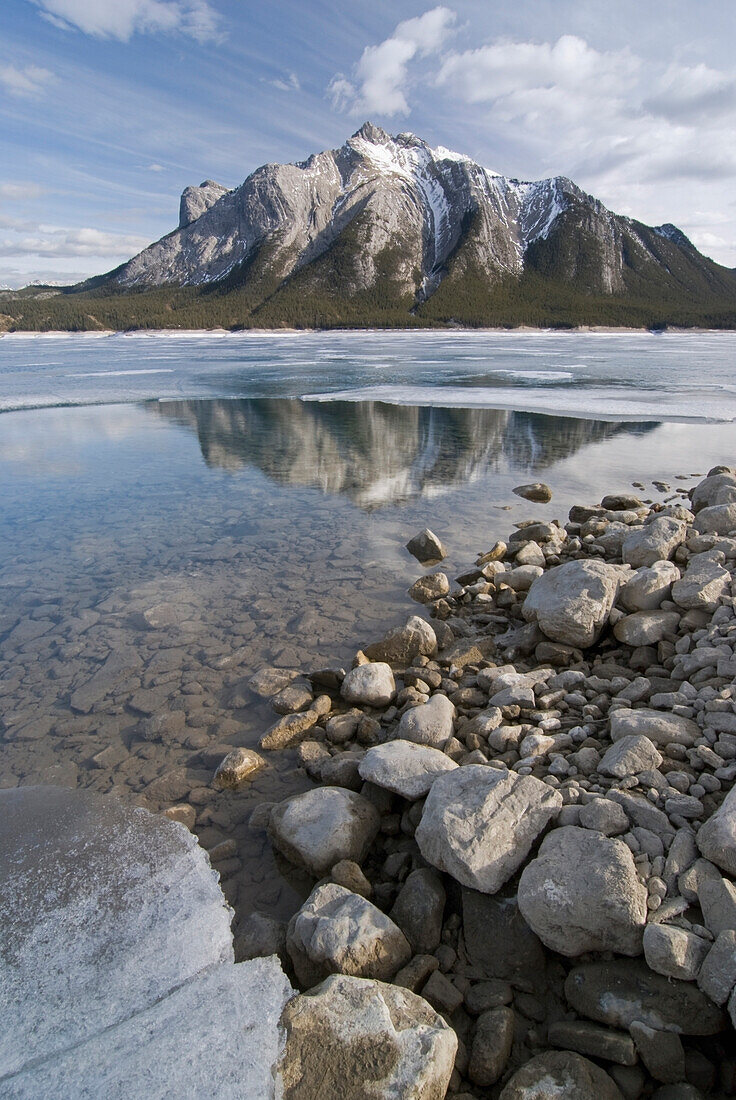 'Alberta, Canada; Reflection Of A Mountain In Frozen Abraham Lake'