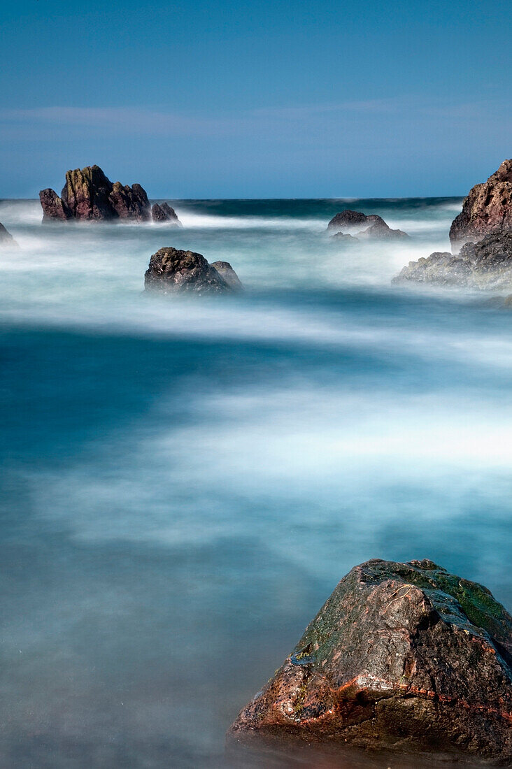 'Mist Surrounding Large Rocks In The Water; Newton, Northumberland, England'