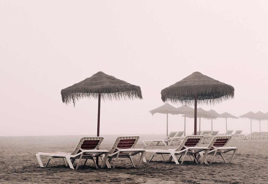 'Sunbeds And Umbrella On Playamar Beach In Off-Season On A Foggy Day; Torremolinos, Malaga, Costa Del Sol, Spain'