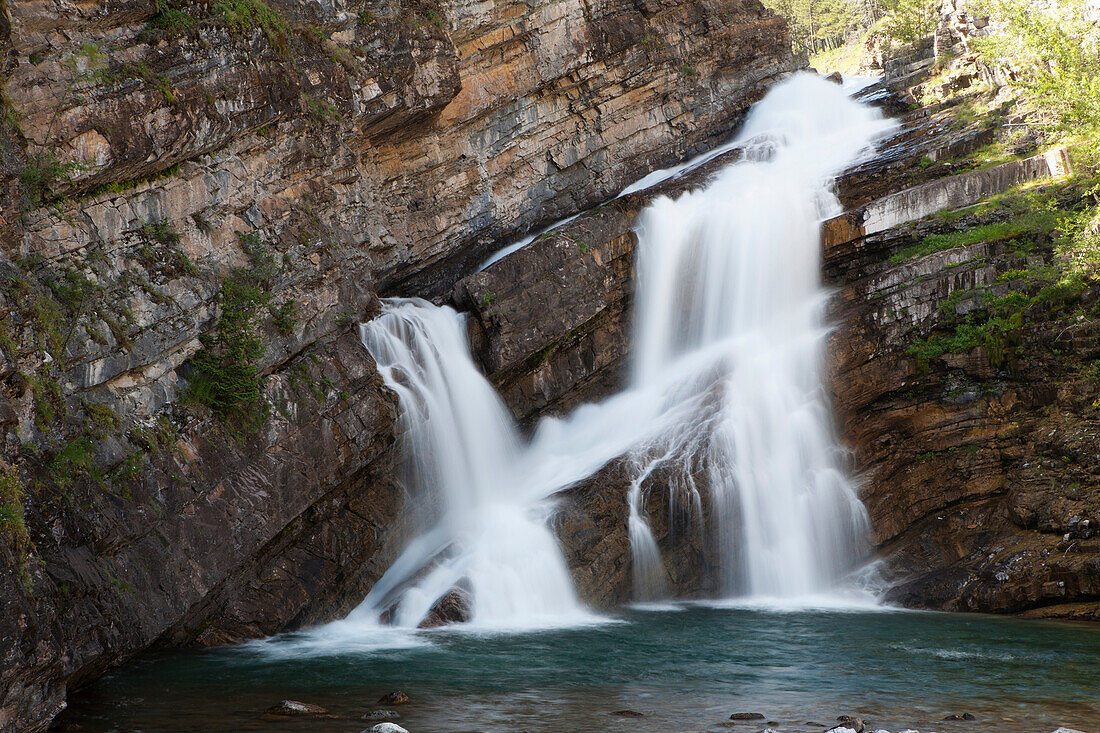 'Waterfalls Coming Out Of A Rock Cliff; Waterton, Alberta, Canada'