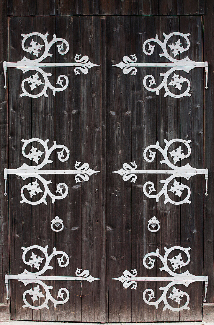 'Large Metal Decorative Hinges On A Weathered Wooden Barn Door; Fussen, Germany'