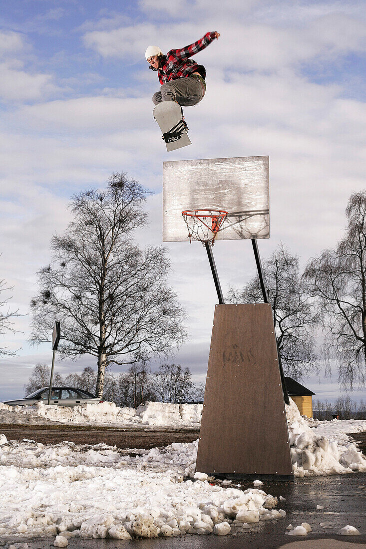 Sweden, snowboarding over a basketball basket