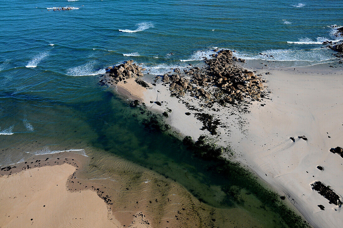 Aerial photograph of a beach, clear water, rock after a sand point
