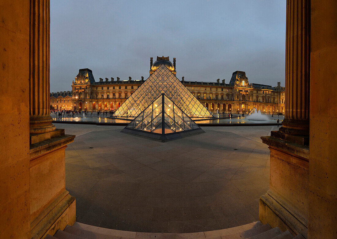 France. Overview of the Louvre in Paris at night. Two columns in the foreground