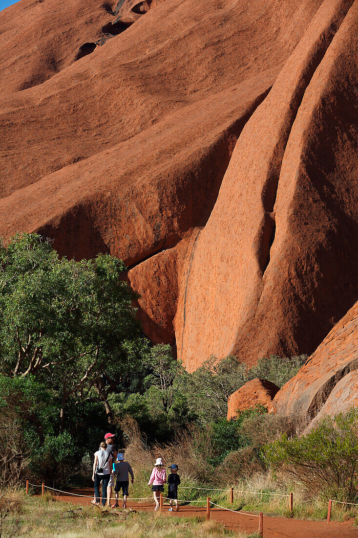 'Tourists walking around Uluru, formerly known as Ayers Rock; Northern Territory, Australia'