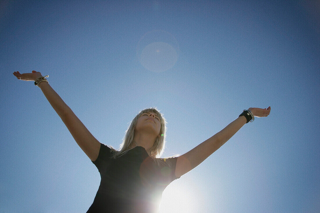 A Woman Raises Her Arms In Praise