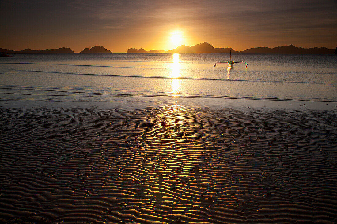 'A Boat Is Silhouetted At Sunset At The Beach; Corong Corong, Bacuit Archipelago, Palawan, Philippines'