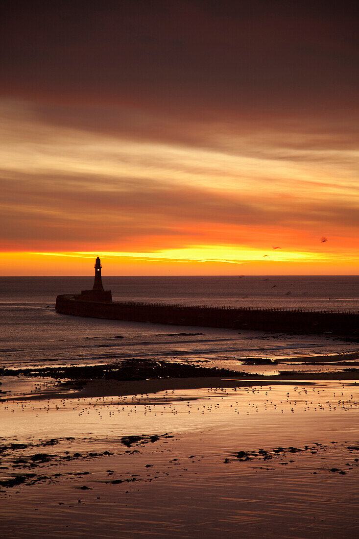 'A Lighthouse At Water's Edge At Sunset; Roker, Sunderland, Tyne And Wear, England'