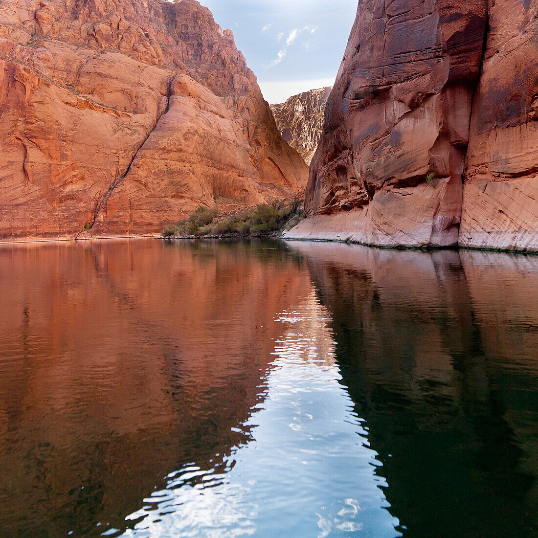 'Steep Rock Cliffs Along The Shoreline Reflected In The Colorado River; Arizona, United States of America'