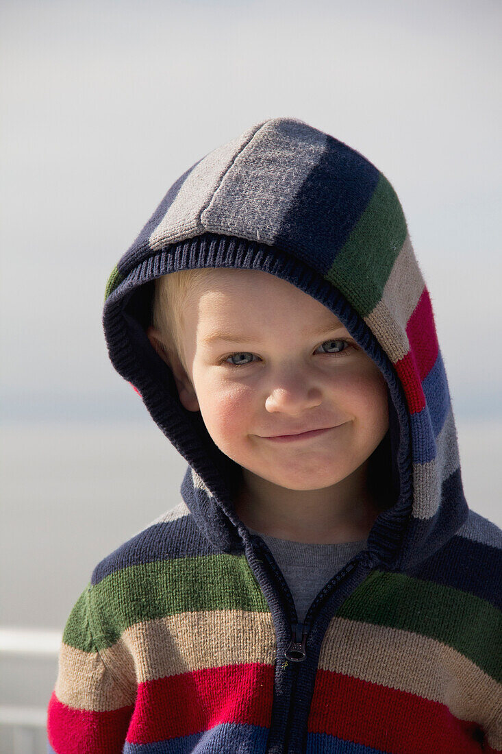 'Young Boy Smiling With A Hood On; Delta, British Columbia, Canada'