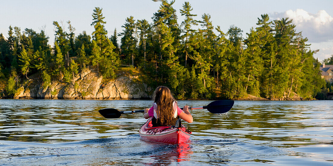 'A Girl Kayaking In The Lake; Lake Of The Woods, Ontario, Canada'