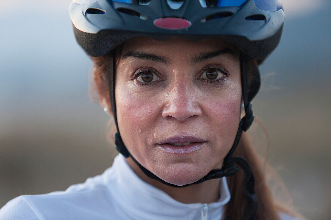 'A Woman In A Bicycle Helmet Dripping With Sweat; Tarifa, Cadiz, Andalusia, Spain'