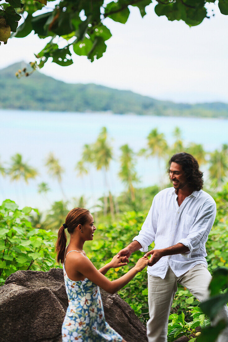 'A Man And Woman Hold Hands With A View Of The Ocean At Bora Bora Nui Resort And Spa; Bora Bora Island Society Islands French Polynesia South Pacific'