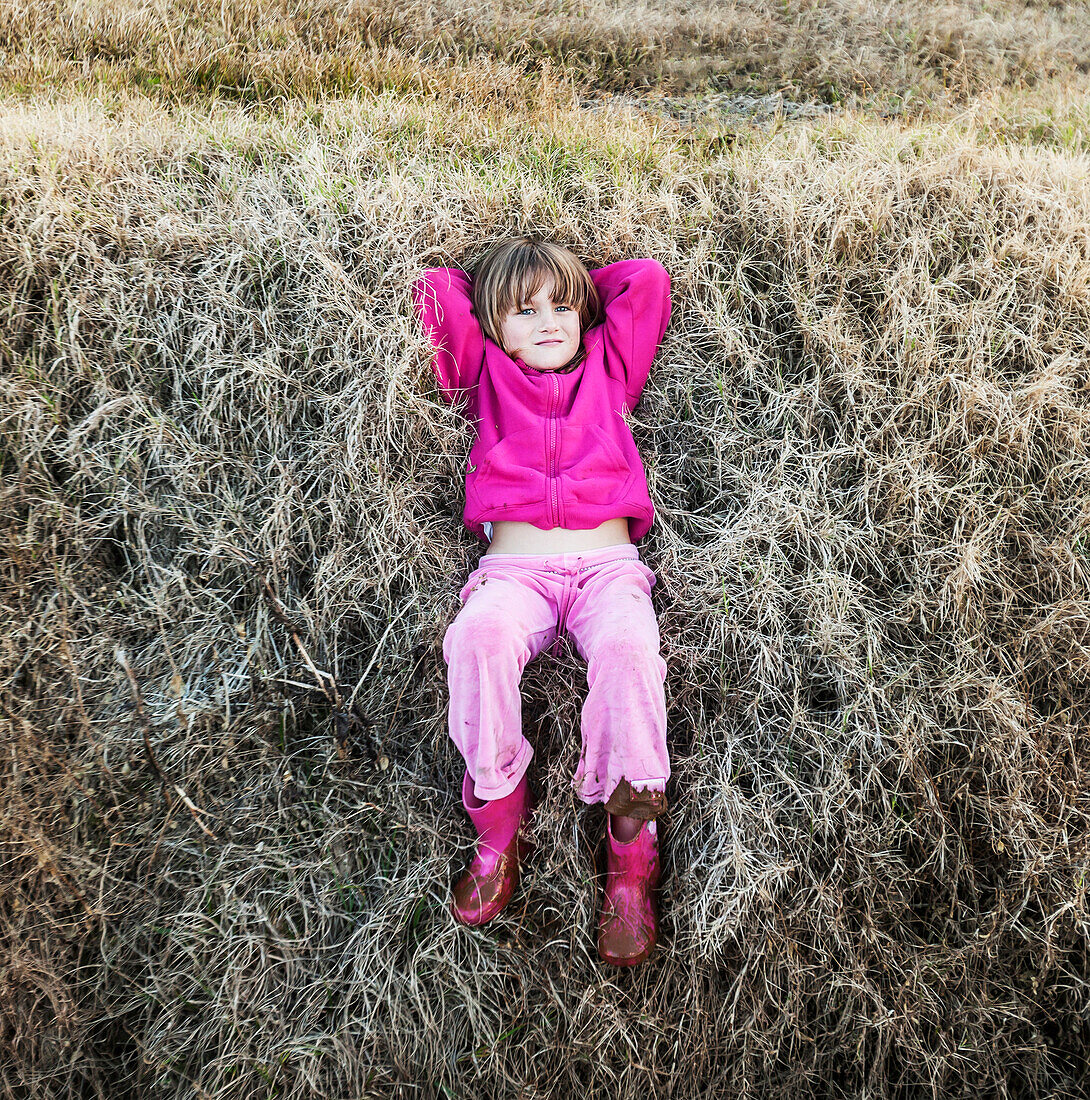 'A young girl wearing pink laying on the grass;Queensland gold coast australia'