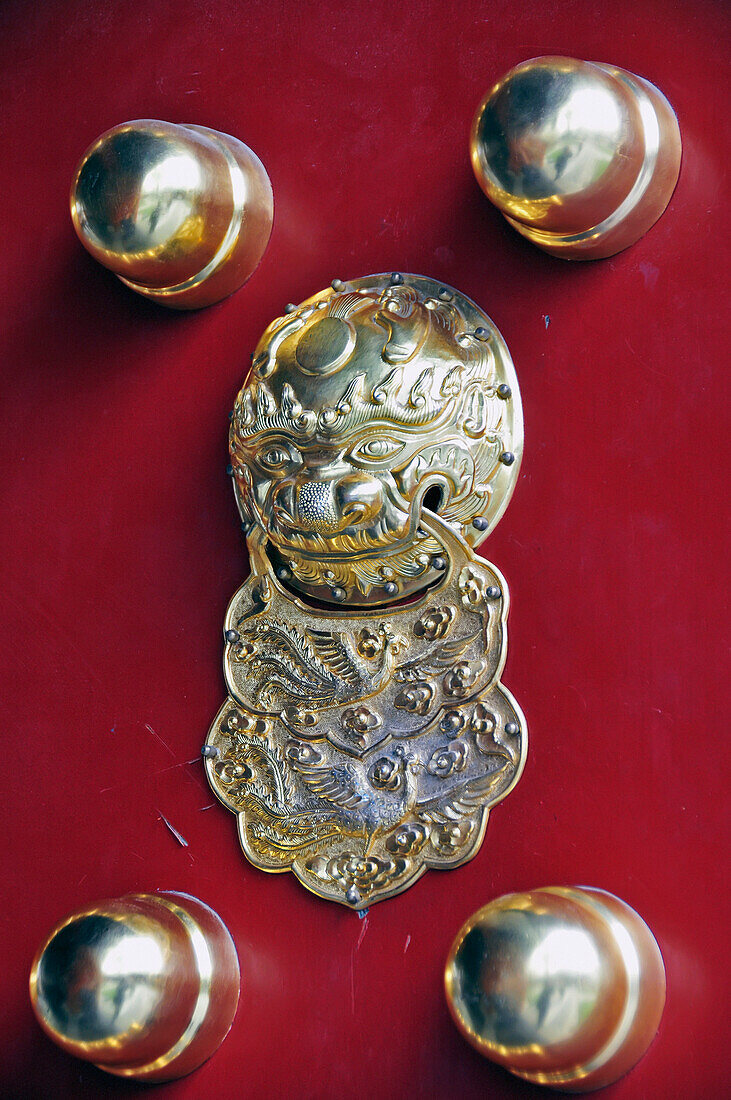 'A gold door knocker on a red door;Beijing china'